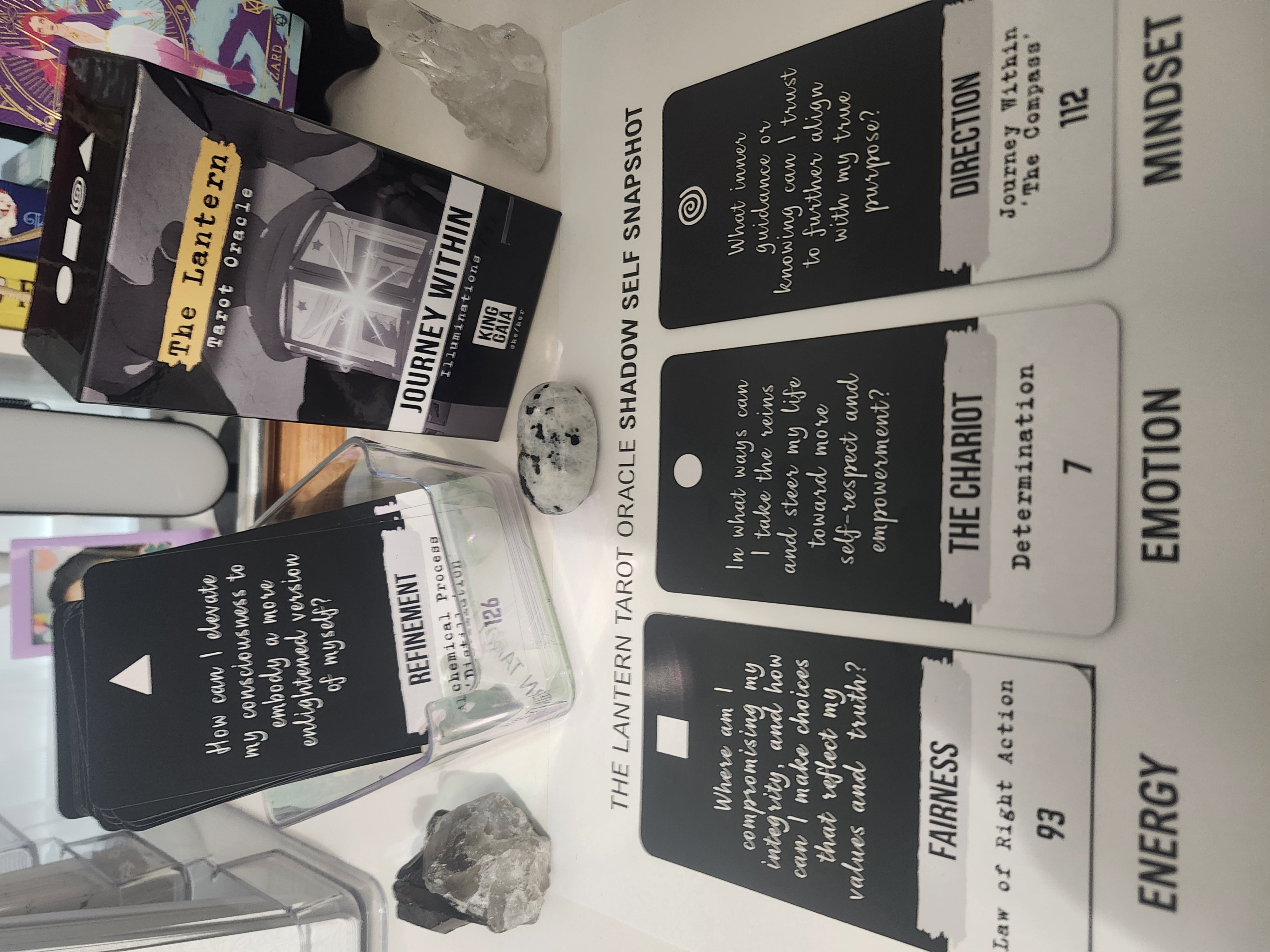 The Lantern Tarot Oracle deck by King Gaia laid out beside crystals, showing cards “Fairness,” “The Chariot,” and “Direction” — a shadow self snapshot offering guidance, clarity, and empowerment.